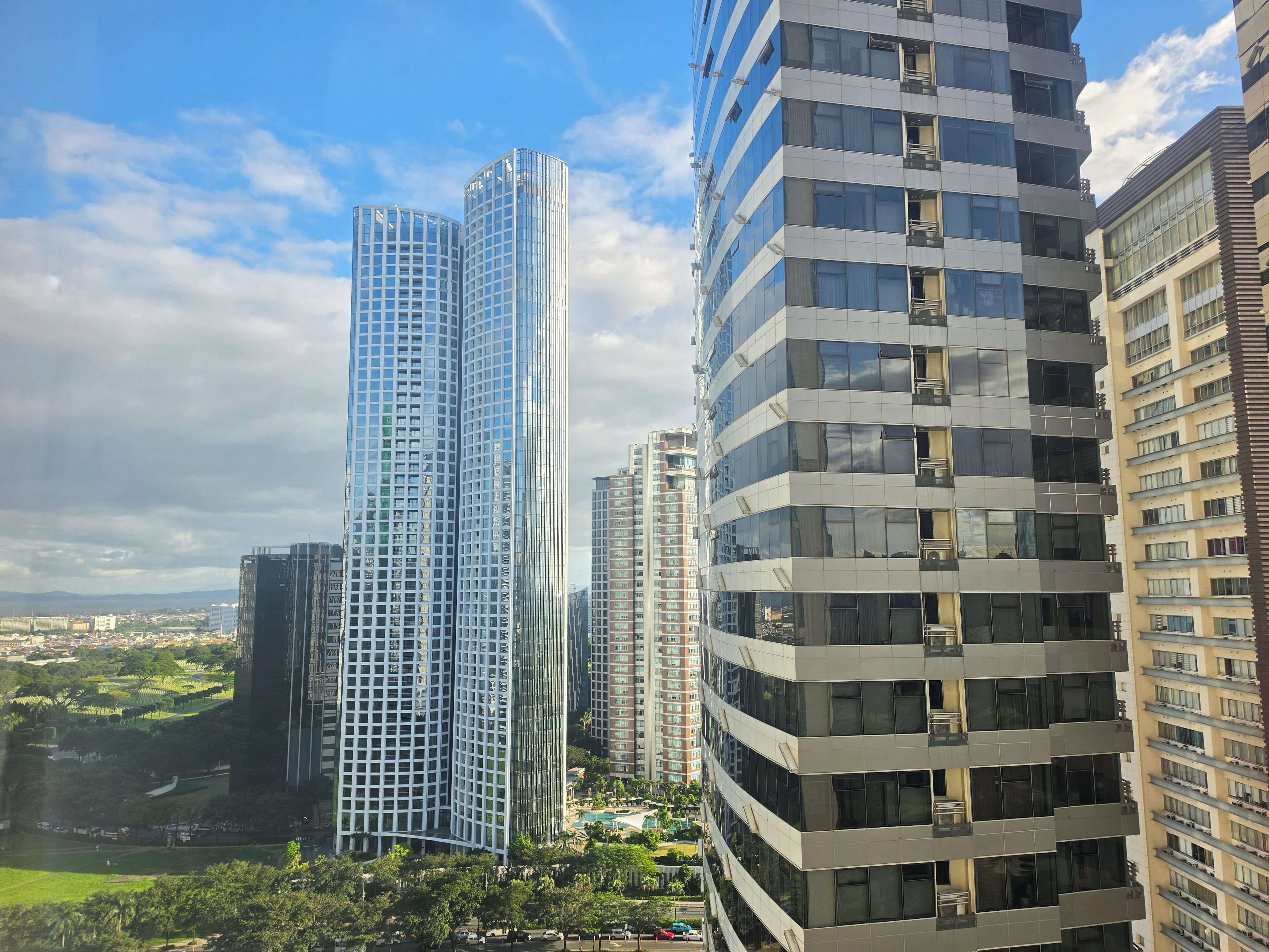 A high-rise building with a modern architectural design, featuring a curved facade and multiple balconies.