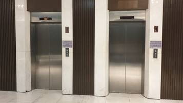 Two elevator doors with a digital display above them.