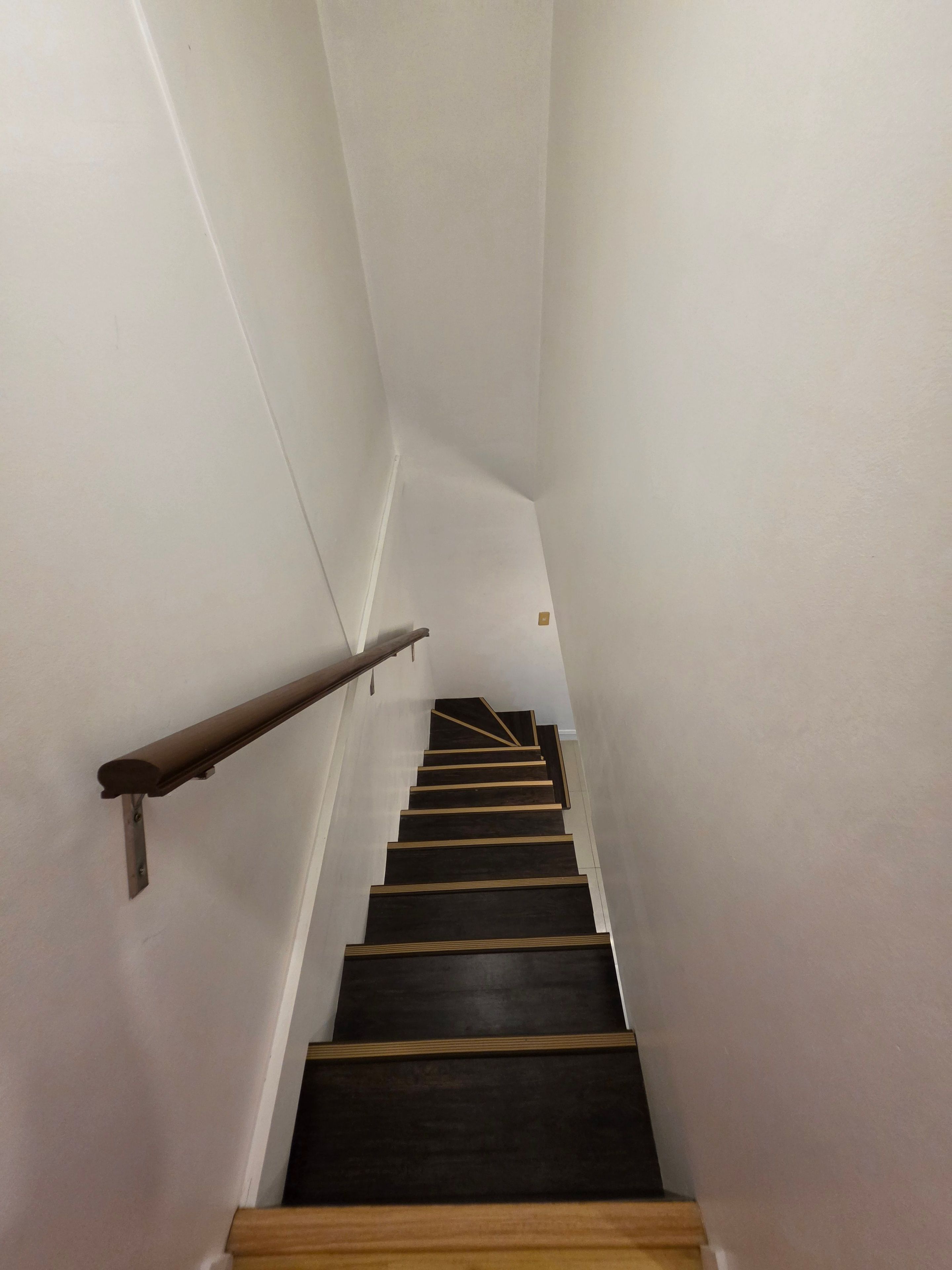 A staircase with wooden steps and a handrail.
