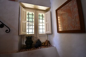 A room with a window, a wall-mounted artwork, and a small shelf with decorative items. - Five Bedroom Estate with Pool and Sweeping Views of Lake and Caccamo (Caccamo)