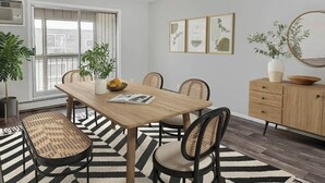 A dining area with a wooden table, four chairs, a bench, a buffet cabinet, and a potted plant. - Cozy MSP 1BR Retreat: Pets OK, Pool & Gym-159/nt, 4499/mn{Negotiable} (Minneapolis)
