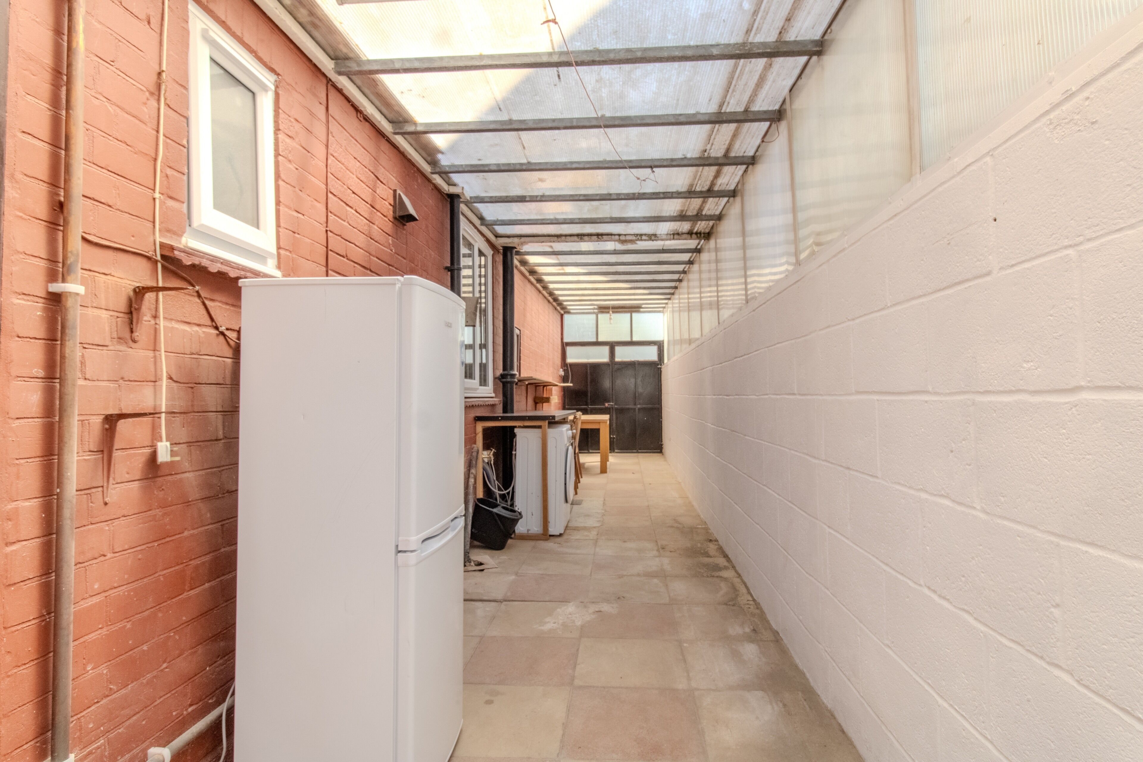 Covered utility passage with natural light and extra storage space