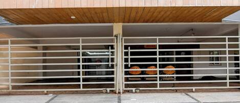 A building entrance with a wooden overhang and a metal gate.