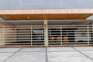 Une entrée d’immeuble avec un auvent en bois et un portail en métal.