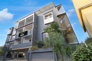 A modern building with a prominent 'Collection' sign, featuring a mix of vertical and horizontal lines, and a balcony with metal railings. - Collection O Infocity Square Bhubaneswar (Bhubaneshwar)