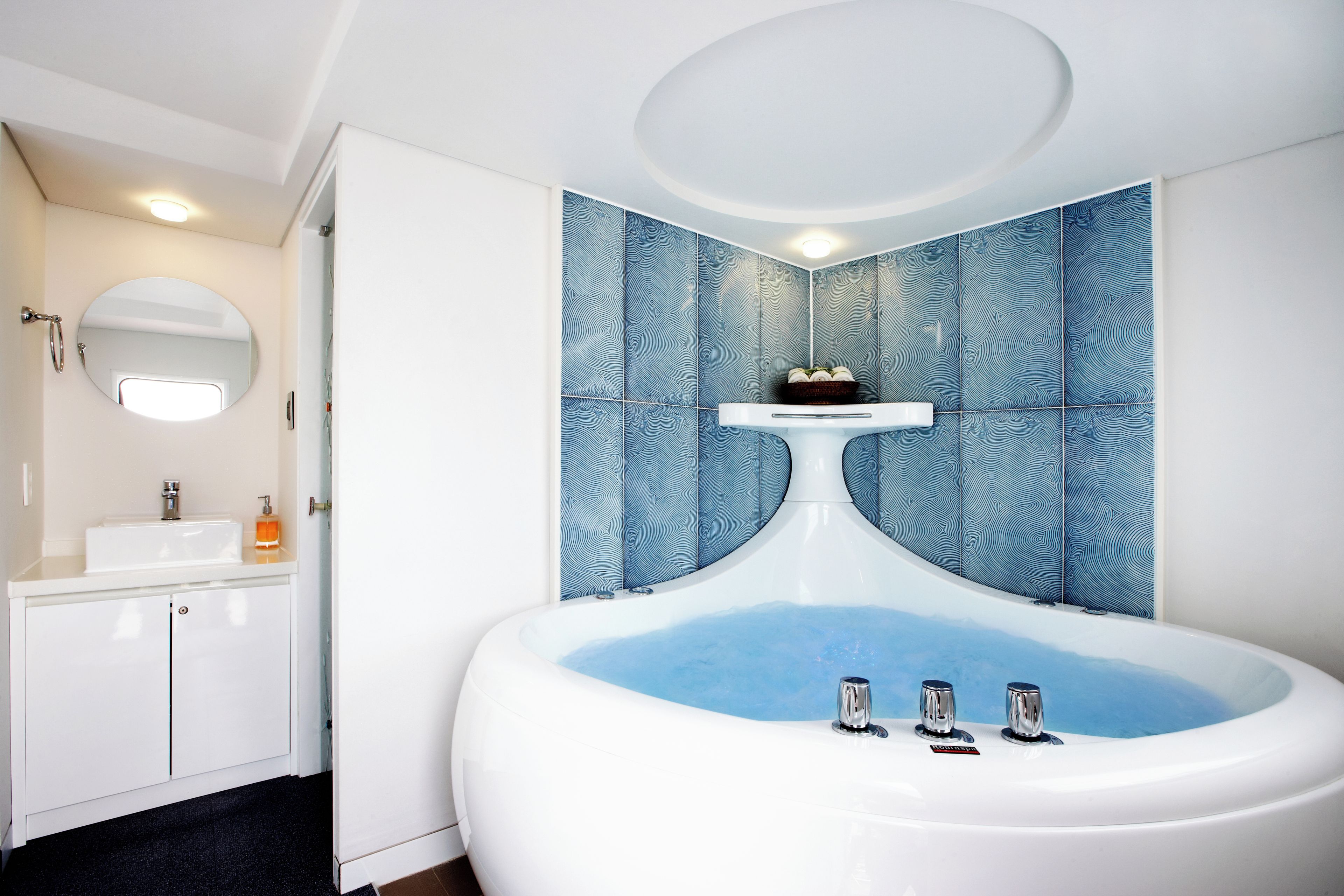 A bathroom with a freestanding bathtub, a sink, and a mirror.