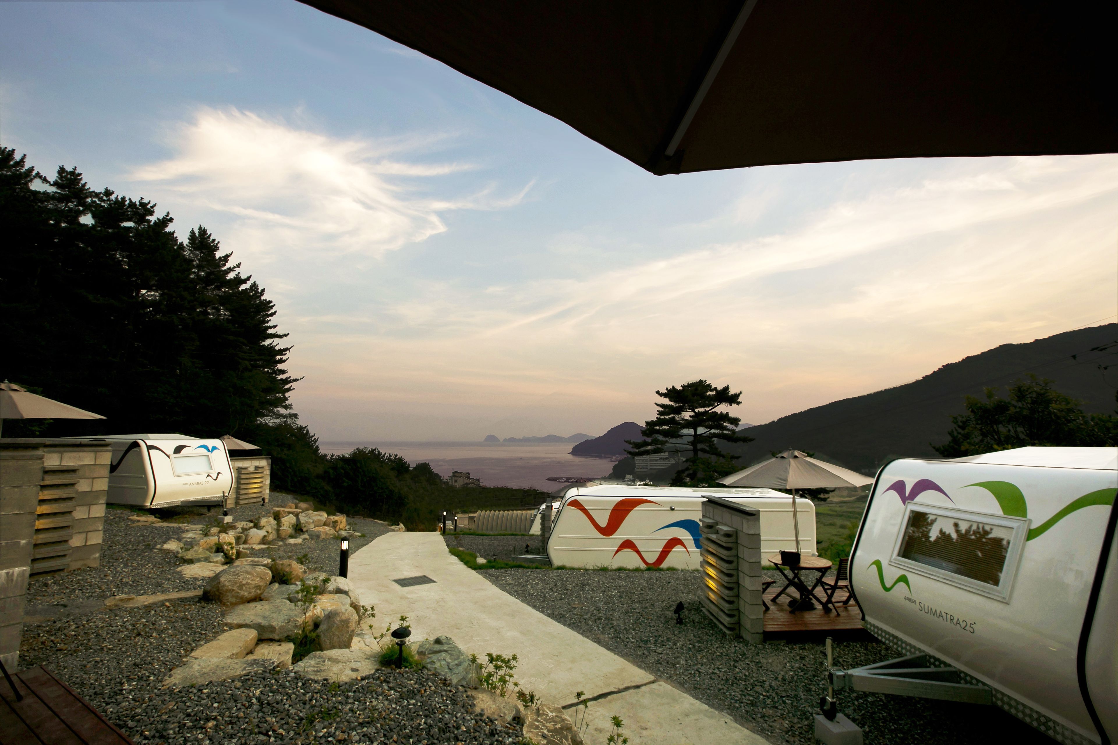 A campsite with RVs, a paved walkway, and a view of the mountains.