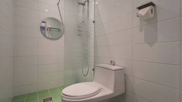 Ein modernes Badezimmer mit Toilette, einer Duschkabine aus Glas und einem Toilettenpapierhalter.