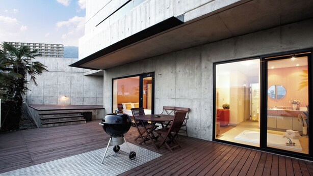 Un patio al aire libre con una parrilla, mesa de comedor y sillas.