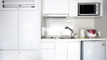 A compact kitchenette with a microwave, a small refrigerator, and a sink.