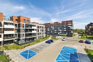 A modern apartment complex with multiple buildings, a parking area, and designated handicapped parking spaces. - Spacious Apartment with a Balcony | Parking | 2 Bedrooms (Katowice)