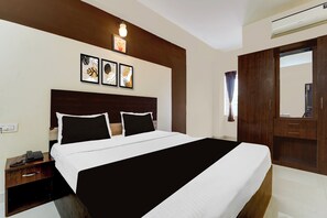 Habitación de hotel con una cama grande, una mesita de noche y un aire acondicionado de pared.