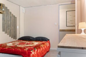 A bedroom with a bed, a bedside table, a lamp, and a wall-mounted artwork. - Apartment 'Villa Andalouse' with Private Terrace, Wi-Fi and Air Conditioning (Poussan)