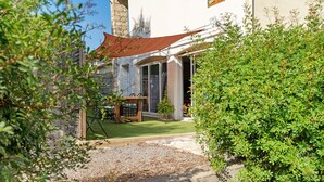 A building with a stone facade, a wooden deck, and a gravel pathway leading to a door. - Apartment 'Villa Andalouse' with Private Terrace, Wi-Fi and Air Conditioning (Poussan)