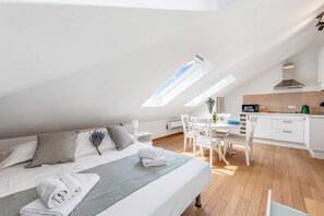 A modern loft bedroom with a skylight, a dining area, and a kitchenette. - Central Loft Sestri Levante (Sestri Levante)