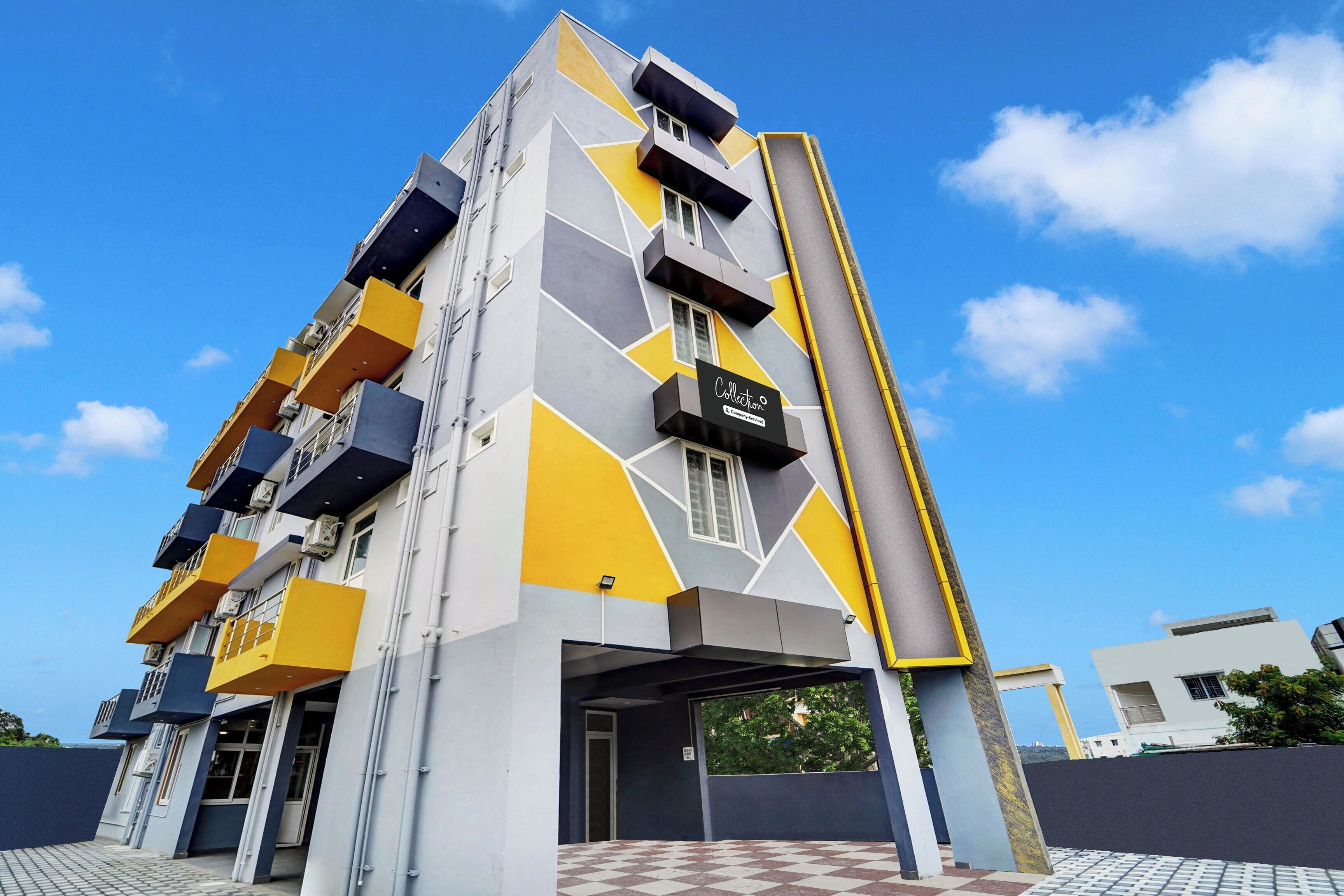 Un immeuble à plusieurs étages doté d’une façade géométrique, de balcons et surplombant un ciel dégagé.