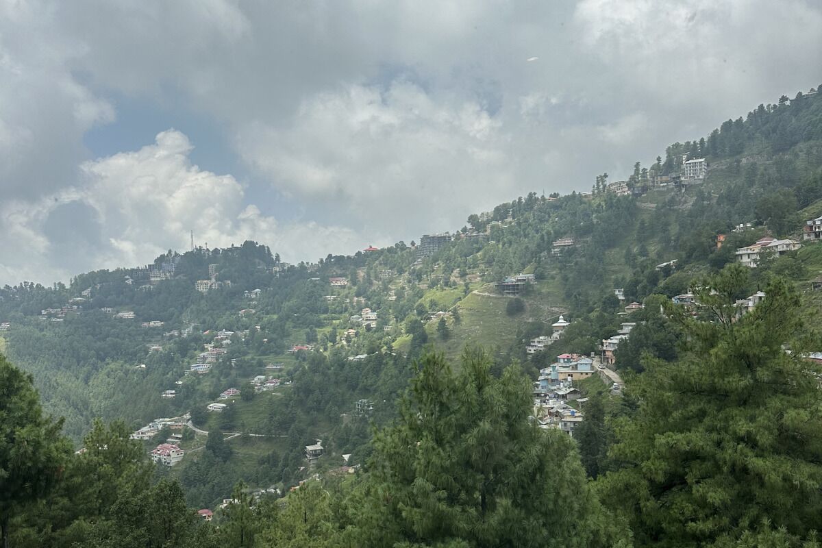 Un paisaje montañoso con edificios dispersos, probablemente una zona residencial.