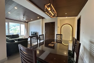 Un comedor moderno con una mesa de vidrio, sillas de madera y una lámpara geométrica original.