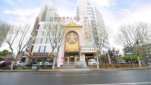A multi-story building with a prominent entrance featuring a decorative archway. - Vienna Hotel Shanghai Yangpu Wujiaochang (Shanghai)