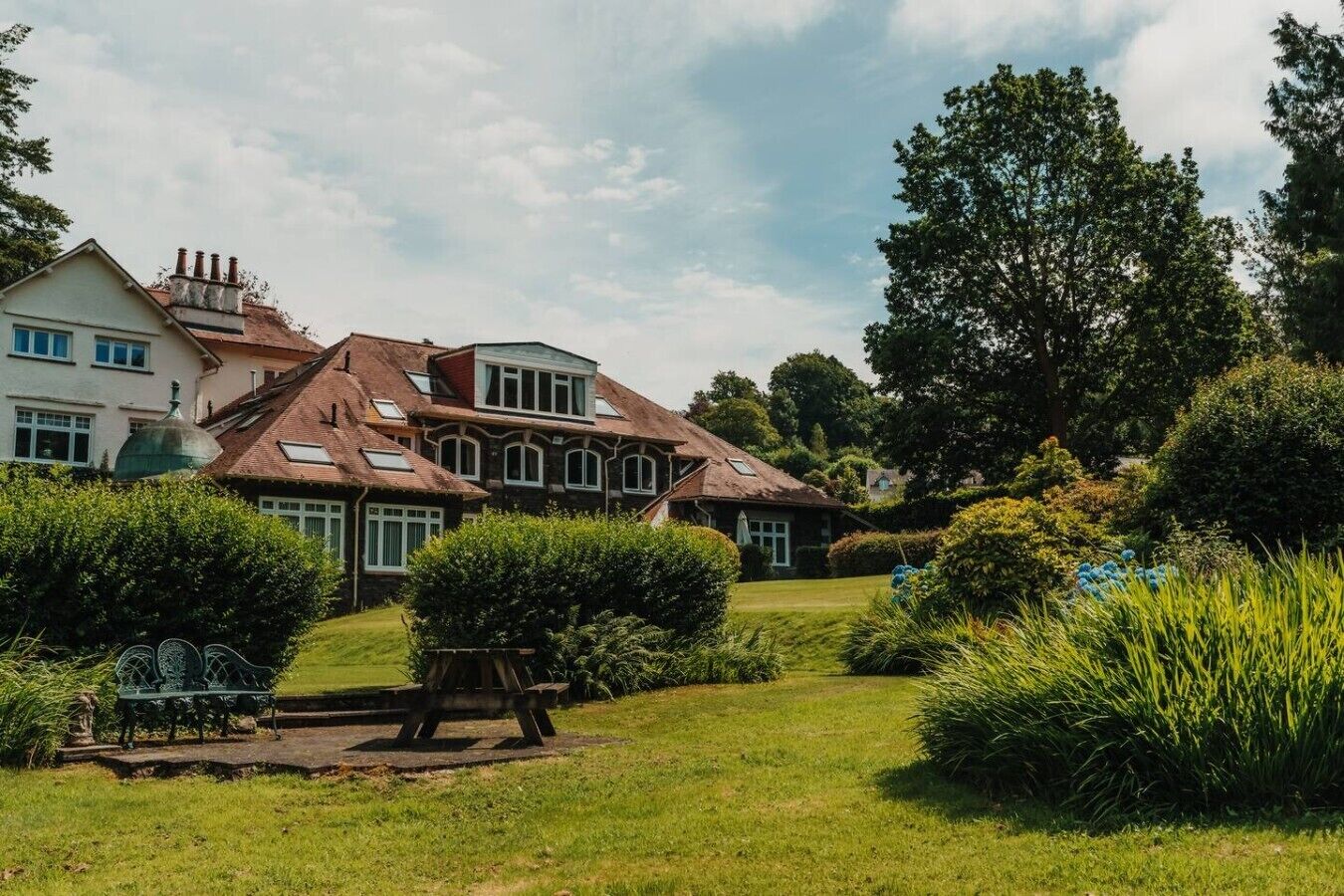 Et stort hus med mange vinduer og en velplejet have.