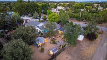Un quartier résidentiel avec des maisons, des arbres et un chemin de terre.