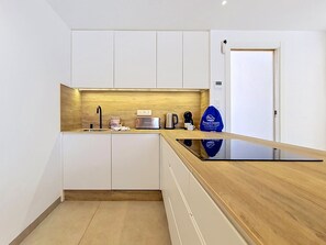 A modern kitchen with white cabinets, a wooden countertop, and a built-in coffee machine. - Private Roof Terrace & Pool View Penthouse (Mar de Cristal)