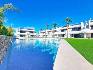 A modern hotel with a swimming pool, palm trees, and a clear blue sky. - Private Roof Terrace & Pool View Penthouse (Mar de Cristal)