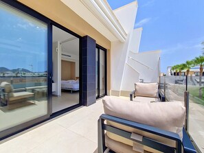 Ein modernes Hotelzimmer mit Balkon, einem Bett und Blick auf die Stadt.