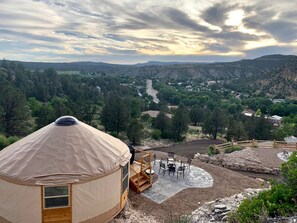 A yurt with a concrete patio, outdoor seating, and a view of a valley. - Majestic Utah Yurt Rental Ideal for Glamping in Zion National Park (Orderville)