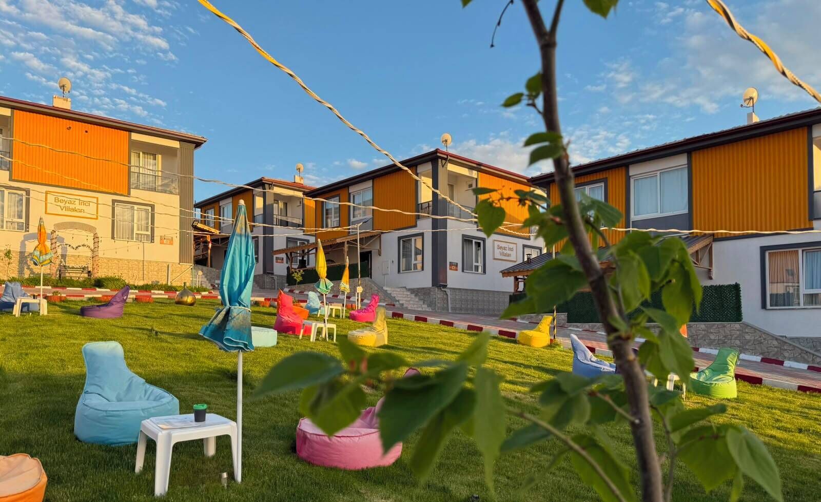 Ein Wohngebiet mit modernen Häusern, einem Rasen und bunter Gartenmöbeln.