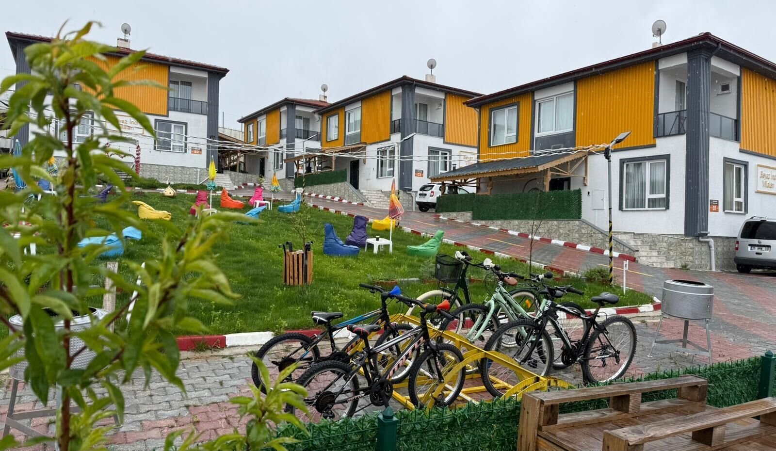 A residential area with modern houses, a grassy courtyard, and bicycles parked.