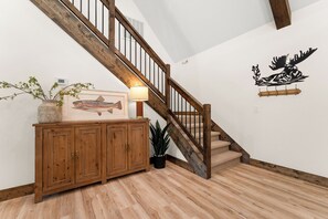 A wooden staircase with a light fixture on the landing. - Wooded Cabin, Hot Tub | Pool, Fishing, Pickleball (Hollister)