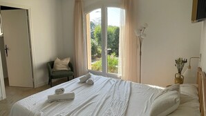 A bedroom with a bed, a chair, a window, and a lamp. - 4-Bedroom Villa with Private Pool near the Sea, Wi-Fi, and Air Conditioning (Saint-Raphaël)