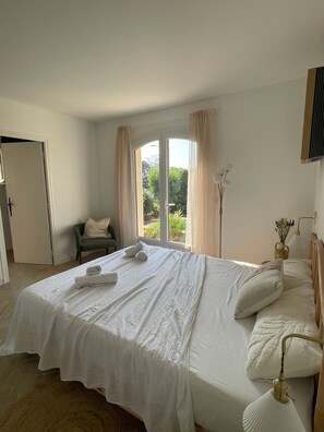 Ett sovrum med en säng, en stol, ett fönster och en lampa.