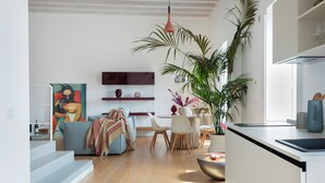Un espacio moderno para vivir con comedor, cocina y una planta grande.