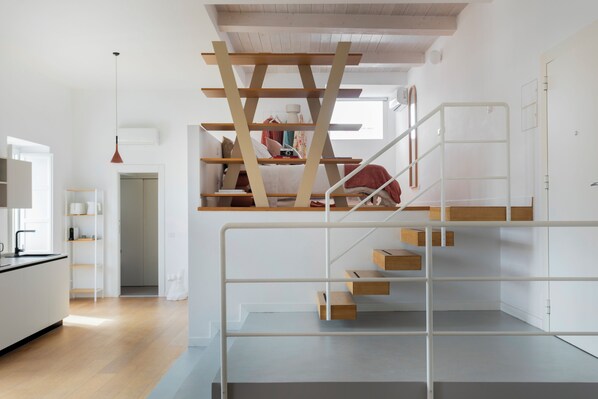 A modern interior with a staircase, a kitchen area, and a living space.