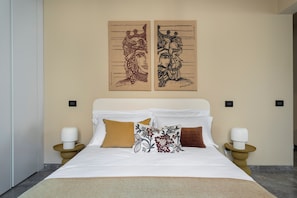 A hotel room with a bed, two nightstands, and two wall-mounted lamps. - Palazzo Valguarnera Luxury Apartments (Palermo)