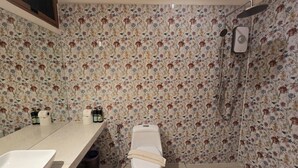 Un baño con inodoro, lavamanos y ducha.
