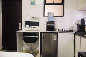 A compact kitchenette with a coffee maker, a water dispenser, a microwave, and a small refrigerator. - Cosy Studio in a Quiet, Accessible Setting (Nairobi)
