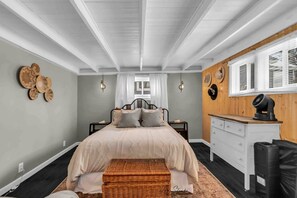 A bedroom with a bed, a dresser, a nightstand, and a wall-mounted hat rack. - Wonderful Secluded Cottage Close to Lake Michigan in New Buffalo, Michigan (Grand Beach)