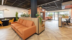Ein modernes Interieur mit einer Couch, einem Schreibtisch und einem Schild mit der Aufschrift 'SNACKS'.