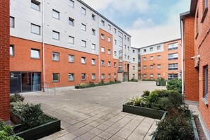 A courtyard with a brick building, a white building, and a clear sky. - Student Only Curzon House (Nottingham)