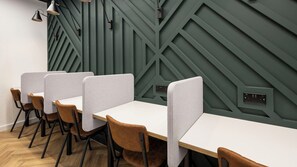 A modern office space with a long table, individual partitions, and brown chairs. - Student Only Curzon House (Nottingham)