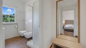 A modern bathroom with a toilet, bidet, and a large mirror. - Villa Carolina Rooms (Castelletto d'Orba)