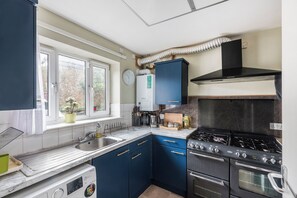 Une cuisine équipée d’une cuisinière, d’un évier et de placards.