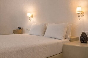 Ein Hotelzimmer mit einem Bett, zwei Nachttischen, einer Lampe und einem dekorativen Gegenstand.