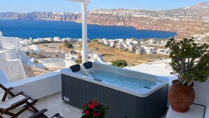 Terraço no telhado com hidromassagem, área de estar e vista para o mar e falésias.