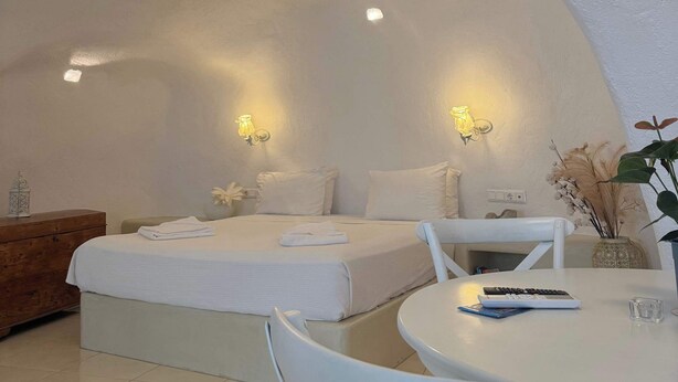 Ein Zimmer mit zwei Betten, einem Esstisch und einem Stuhl.