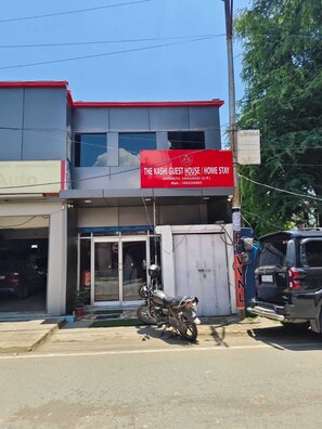 A building with a red sign for 'The Kashi Guest House / Home Stay' in Sarnath, Varanasi.