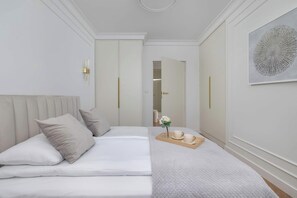 A hotel room with a bed, a bedside table with a vase and teacups, and a large abstract painting on the wall. - Air-conditioned Apartment with a Garden | 2 Bedrooms | Workspace (Gliwice)